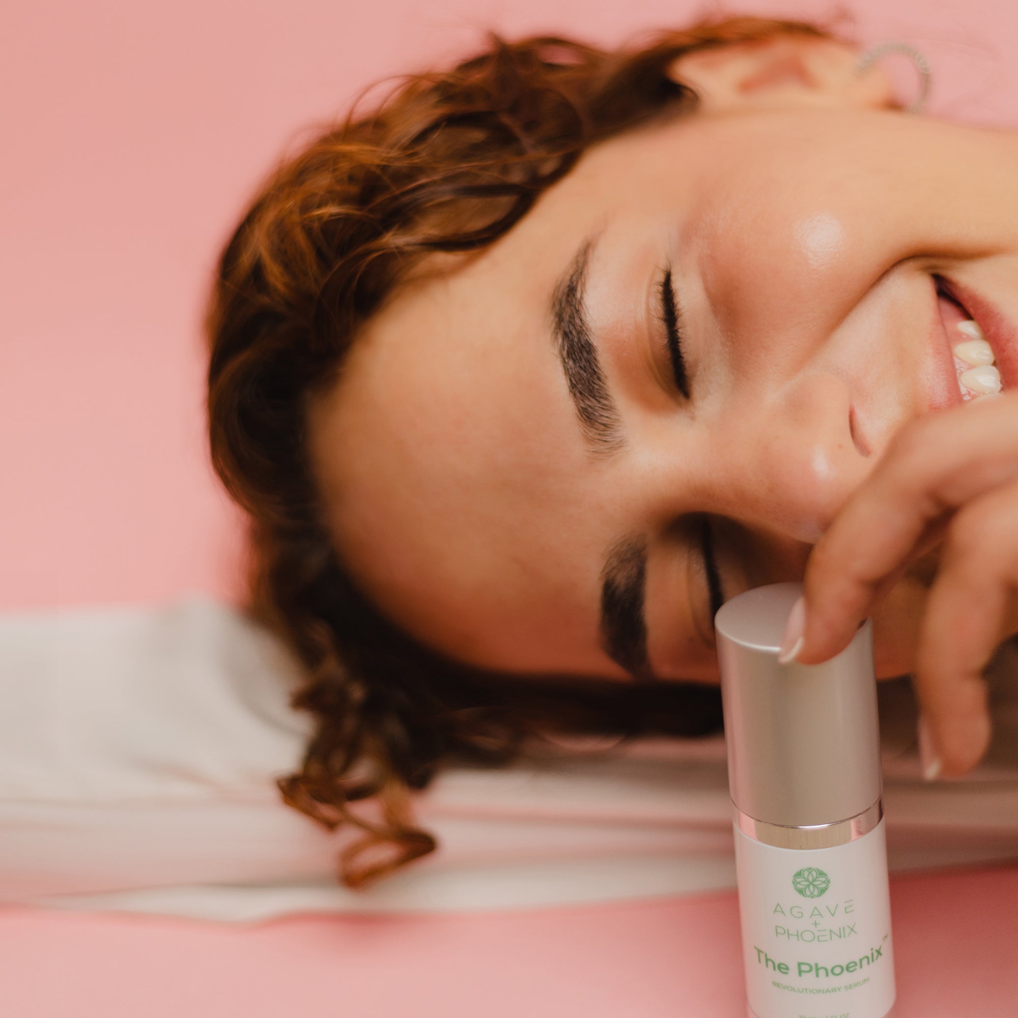 Model holding The Phoenix serum — showcasing the hydrating skincare essential from Agave Phoenix.