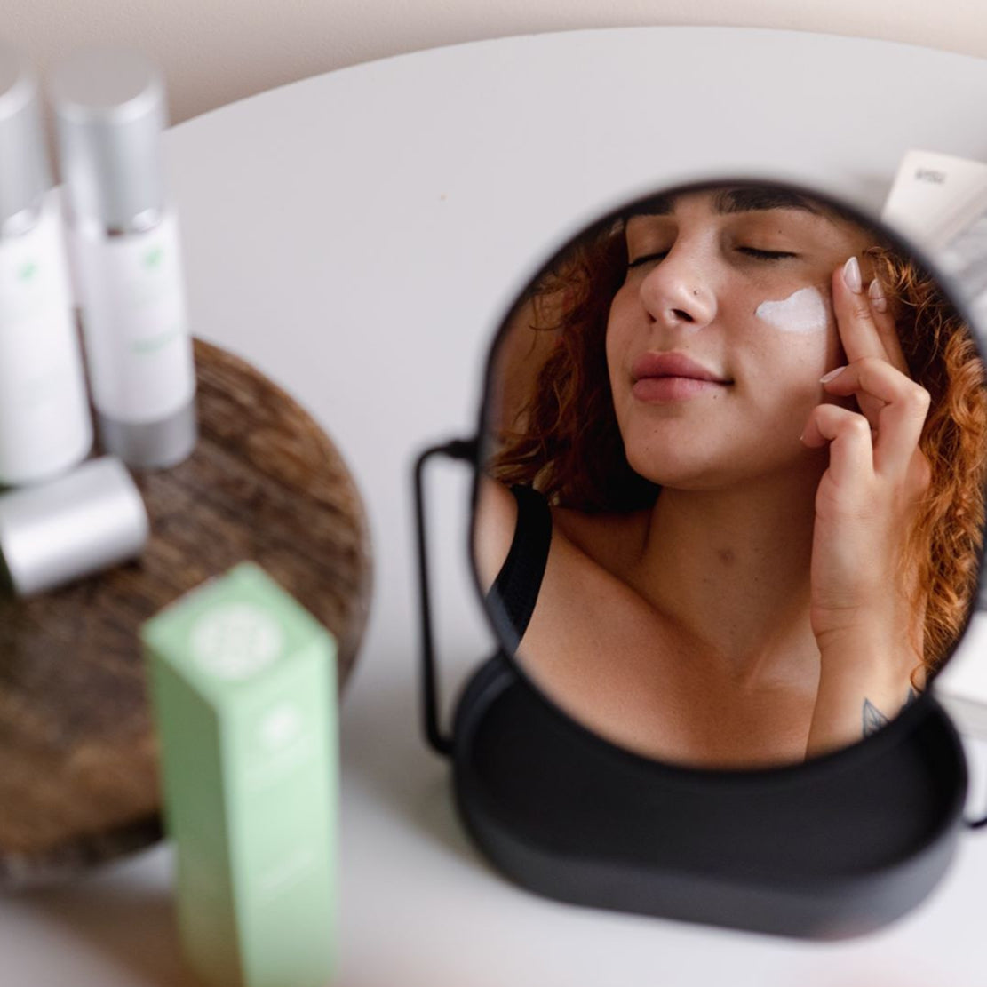 Model gently applying Agave Phoenix moisturizer — nourishing skincare for hydrated, glowing skin.