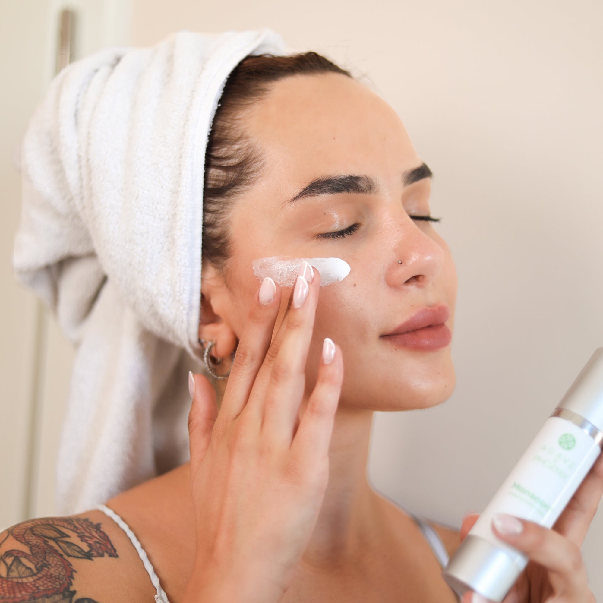 Model gently applying Monsoon Advanced Moisturizer — rich hydration and anti-aging care for soft, firm skin.